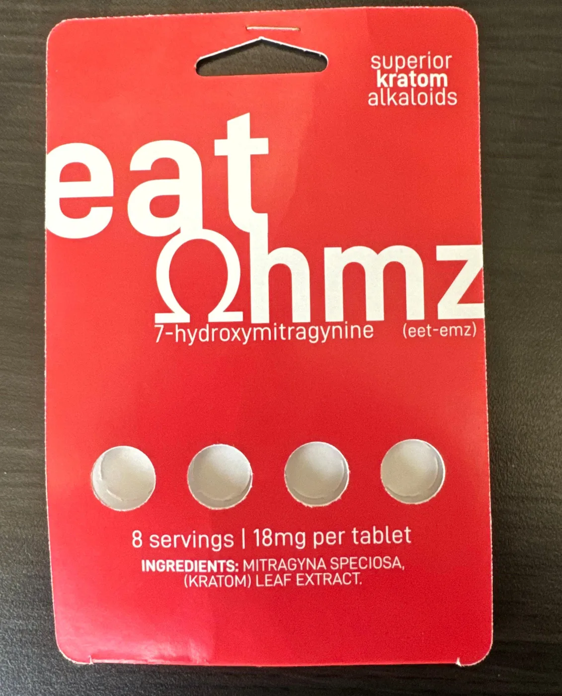 A red blister card reading eat Ohmz, 7-hydroxymitragynine (eet-emz), superior kratom alkaloids, with four round tablets, 8 servings, 18mg per tablet, Ingredients: Mitragyna speciosa (kratom) leaf extract.