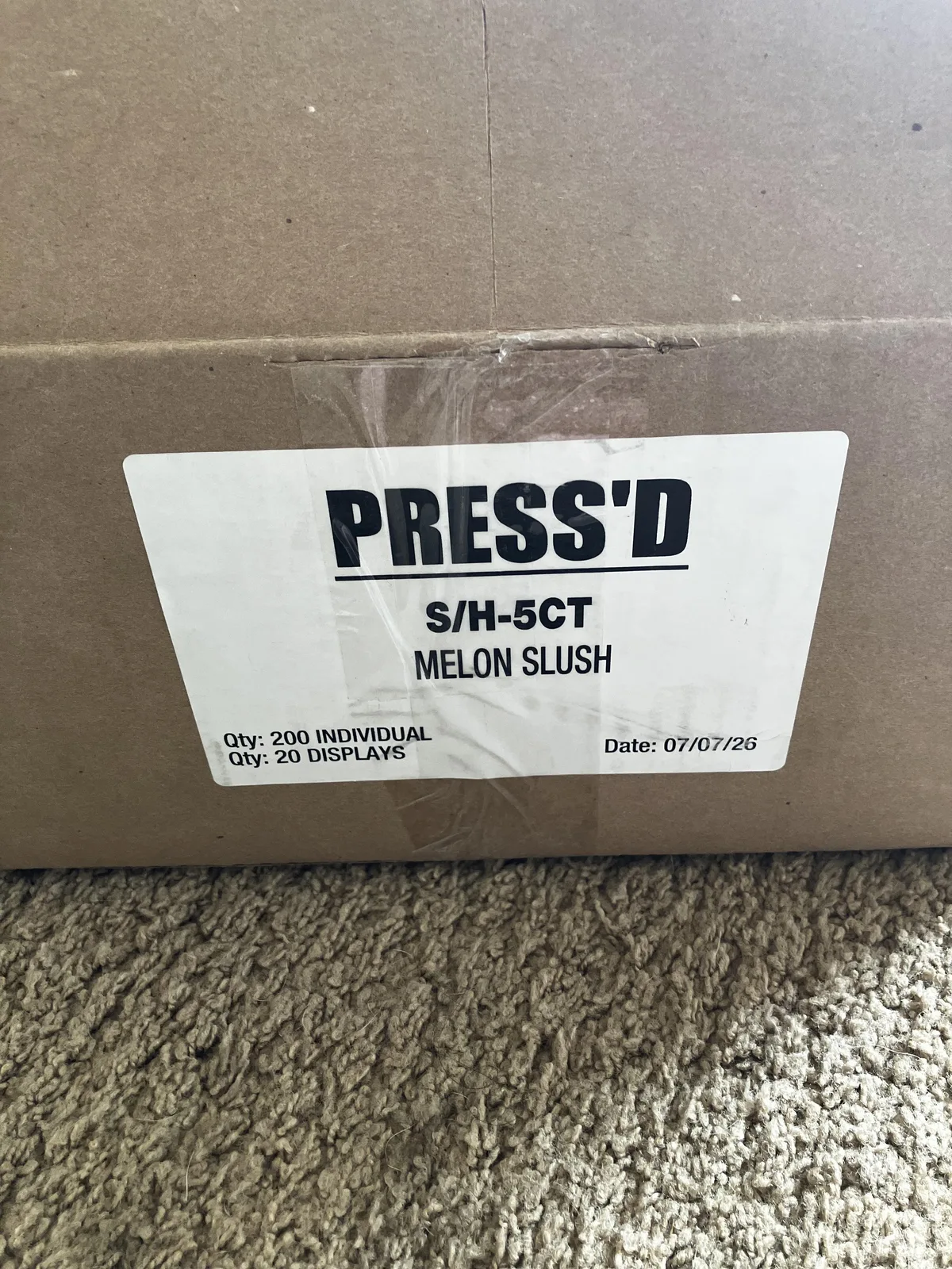A cardboard carton with a white label: PRESS'D, S/H-5CT, Melon Slush, Qty 200 individual, Qty 20 displays, Date 07/07/26.