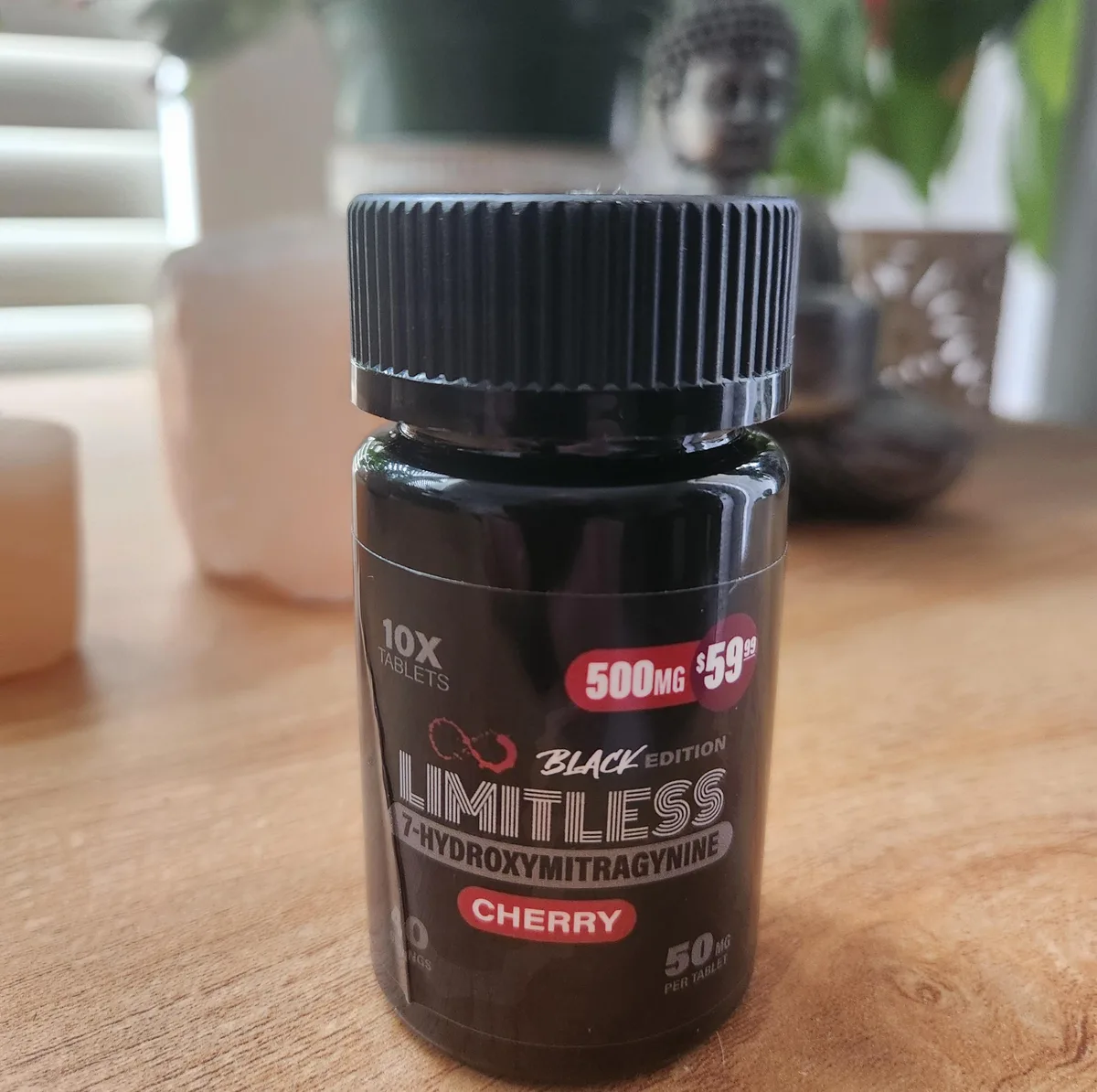 A black plastic bottle on a table: 10X tablets, 500 MG, 59.99 dollars, Black Edition, LIMITLESS 7-HYDROXYMITRAGYNINE, Cherry, 50 mg per tablet.