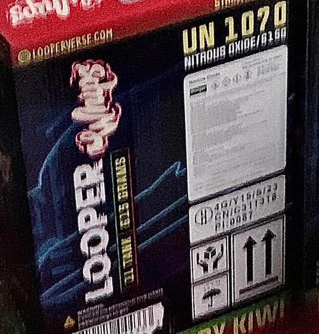 Close crop of one carton: an Instagram-style mark and the words LOOPERVERSE.COM along the top edge, LOOPER Whips 1L tank 615 grams down the side, and a UN 1070 nitrous oxide label with a packaging code block.