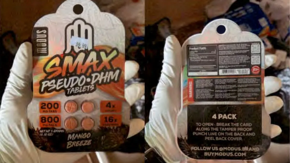 A gloved hand holding the front and back of a card: Modus, Smax Pseudo-DHM Tablets, 200 mg tabs, 800 mg pack, 4 count, 16 servings, Mango Breeze, with a price sticker; on the back a product facts panel, a warning panel, and Follow us @modus.brand, buymodus.com.