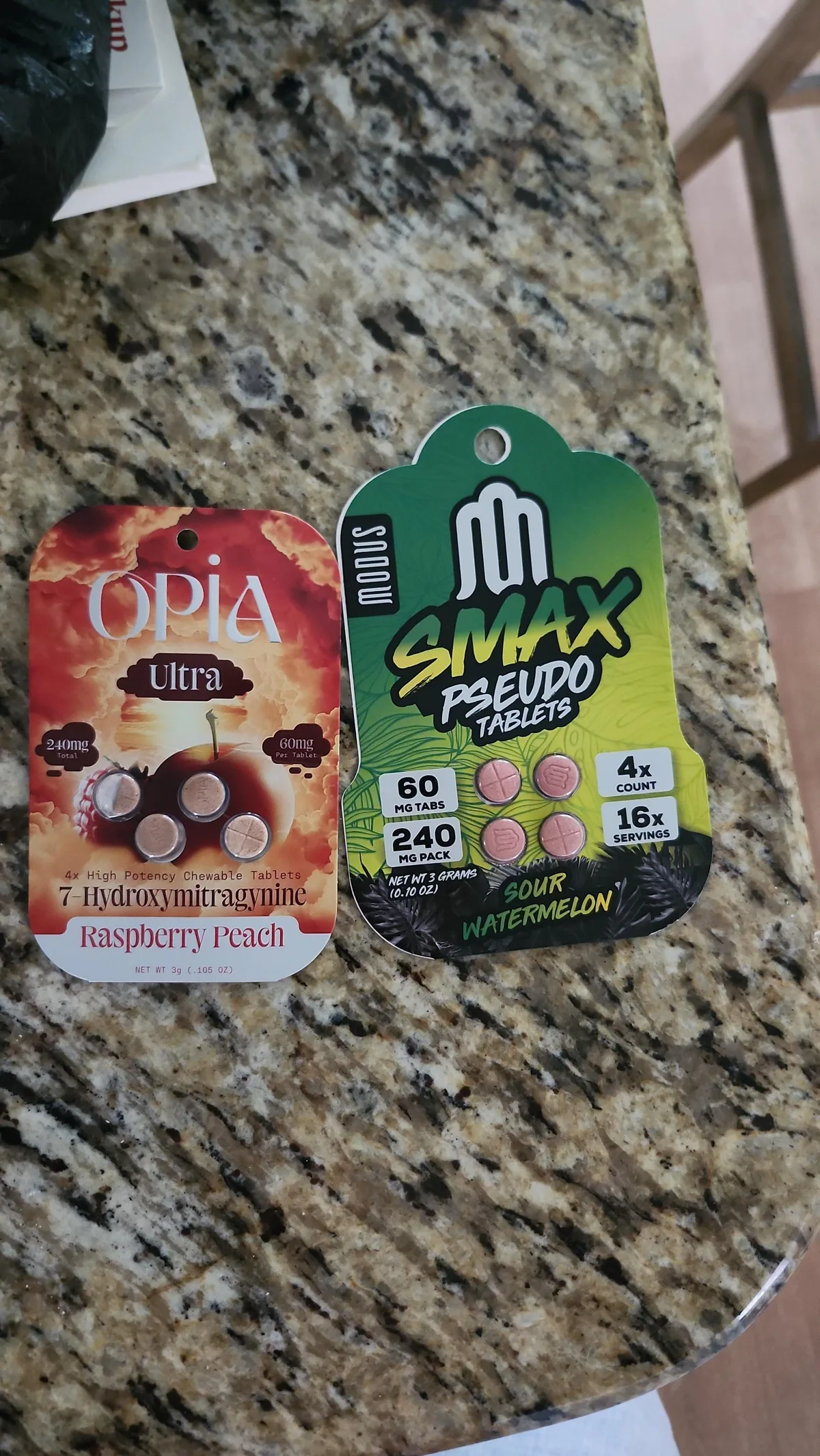 Two cards on a granite counter: an Opia Ultra 7-Hydroxymitragynine card, 60 mg per tablet, and a green Modus Smax Pseudo Tablets card, 60 mg tabs, 240 mg pack, 4 count, 16 servings, sour watermelon.
